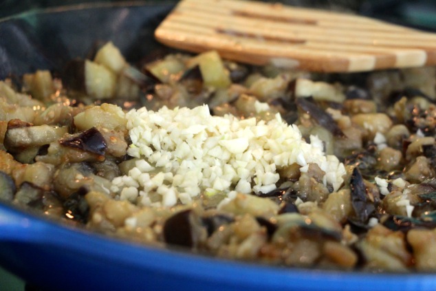 adding garlic to eggplants