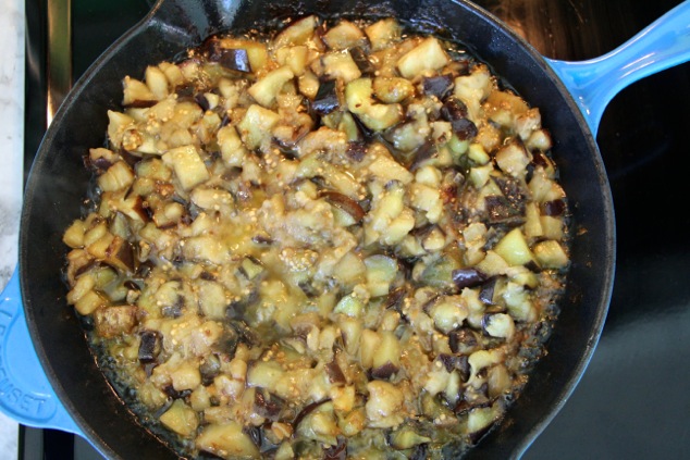 eggplants cooking down in pan