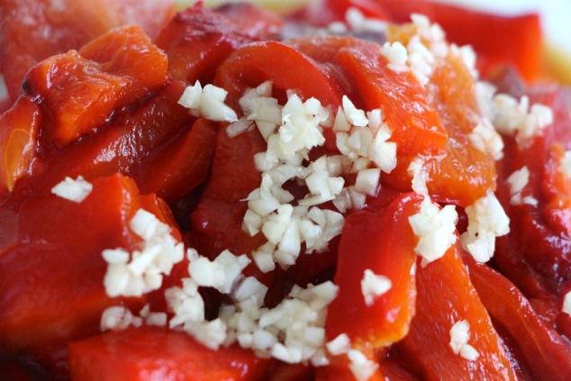 adding garlic to roasted peppers