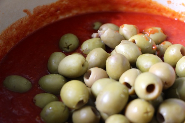 adding green olives to sauce