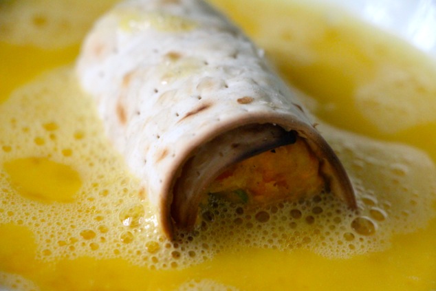 dipping matzah eggroll into egg