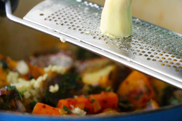 grating ginger root into pot