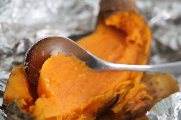 scooping sweet potato flesh