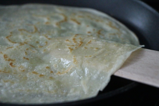 flipping a crepe in pan