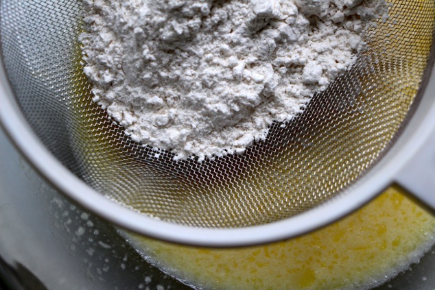sifting flour into batter