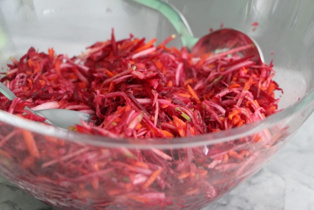 mixing beet slaw in bowl