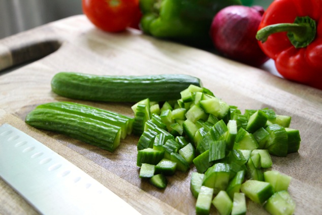 cutting cucumber on cutting board