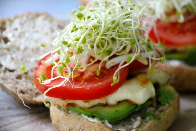 adding sprouts onto sandwich