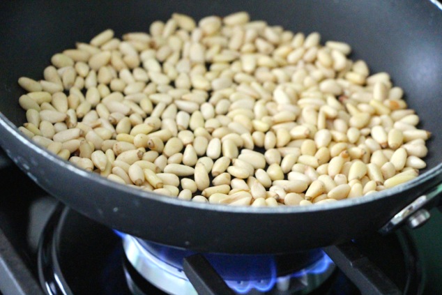toasting pine nuts in a pan