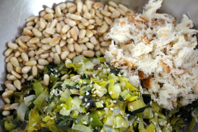 leek mixture with pine nuts and bread in a bowl