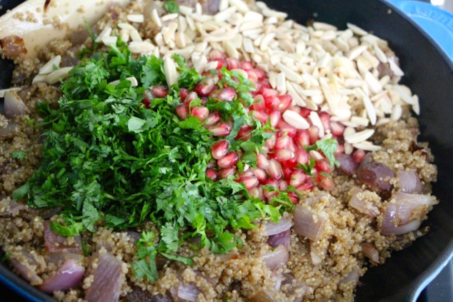 adding cilantro pomegranate and almonds to quinoa