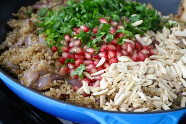 adding cilantro pomegranate and almonds to quinoa side