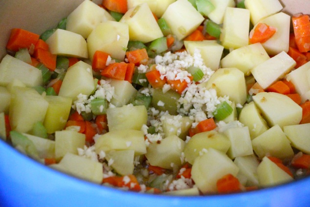 adding chopped garlic to the pot