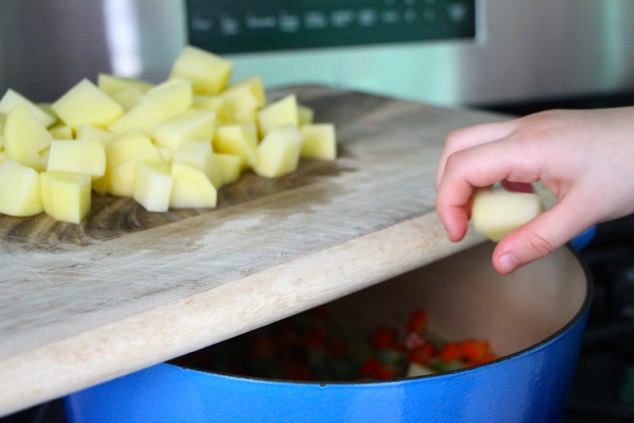 adding potatoes to the soup