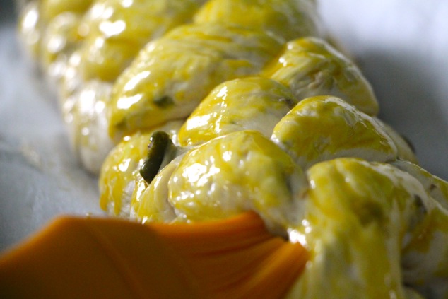 brushing egg yolk on challah up close