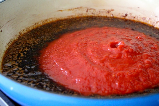 adding crushed tomatoes