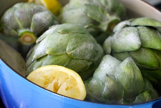 adding salt to artichoke pot