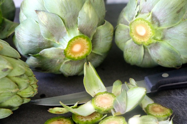 cutting the stem off the artichokes