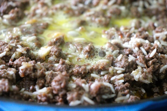 mixing egg into the meat mixture up close