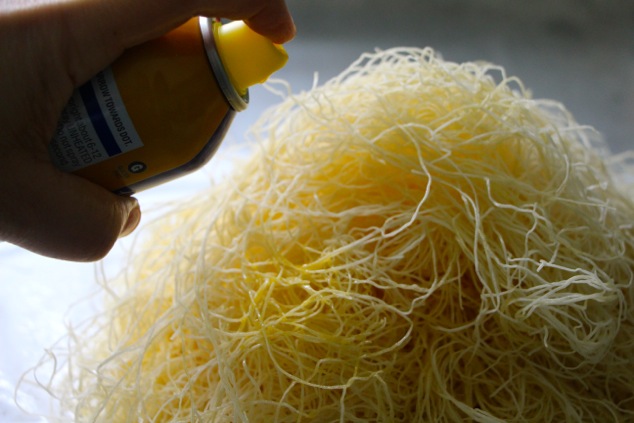 spraying oil onto kadaif pastry dough