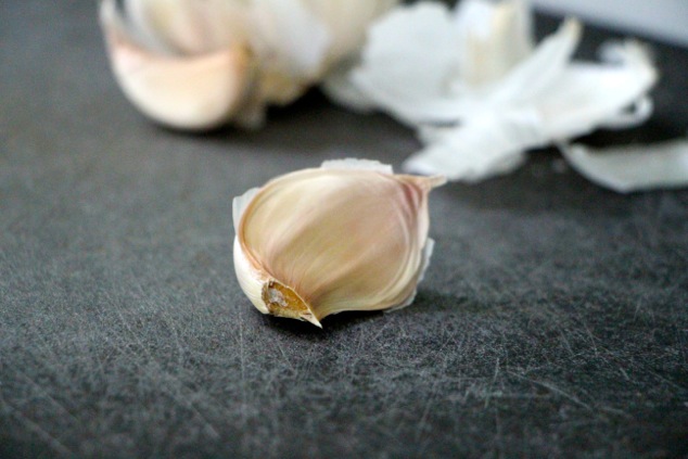 one garlic clove on a cutting board