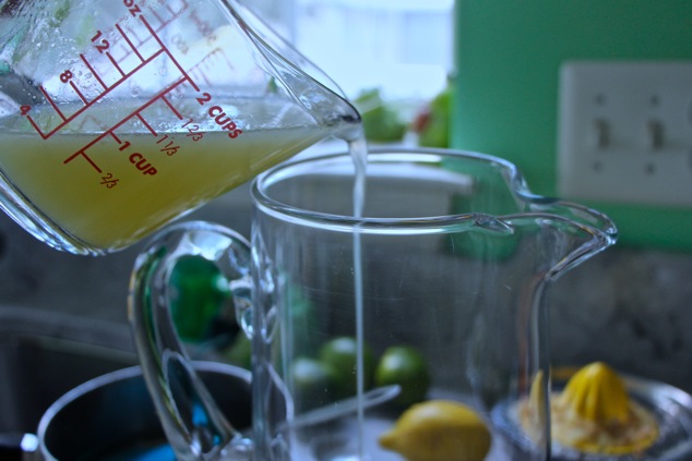 pouring lemon juice into a pitcher