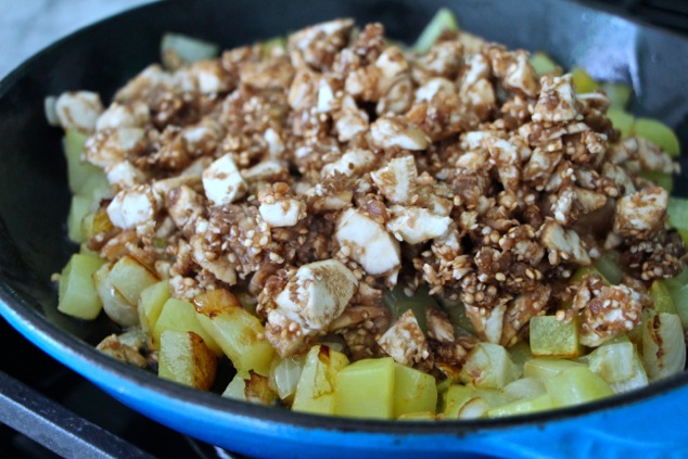 adding chopped eggplant to pan