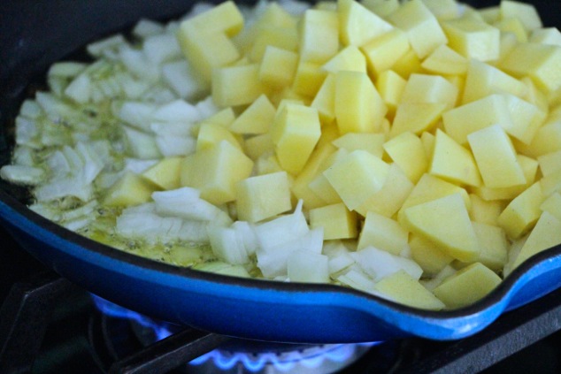 onion and potato cubes in a pan