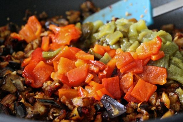 adding chopped roasted peppers to the pan