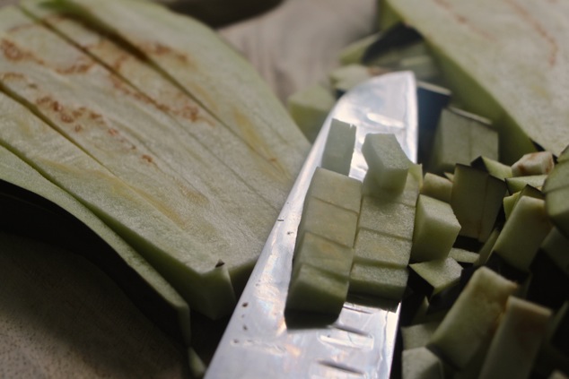 cutting eggplant into cubes up close