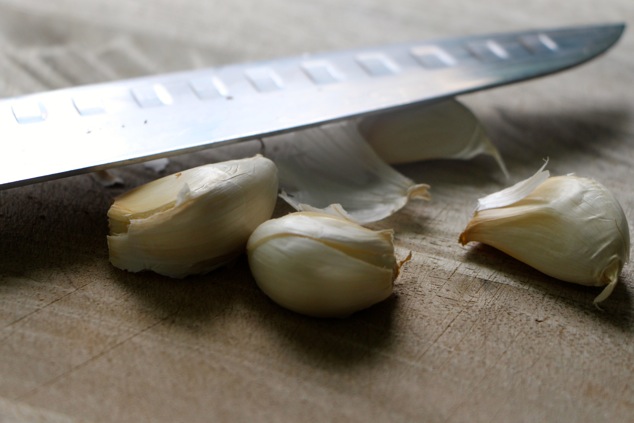 garlic cloves on a cutting board