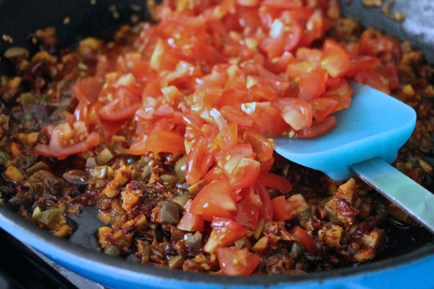 adding chopped cherry tomatoes