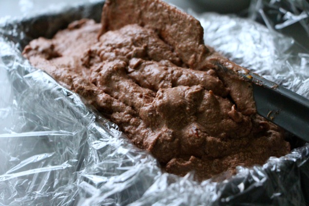 pouring Nutella mousse in cake pan with plastic wrap