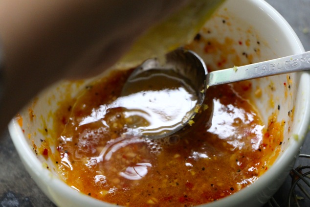 squeezing lemon onto salad dressing