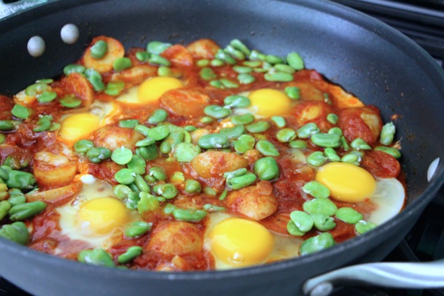 adding blanched fava beans to the shakshuka