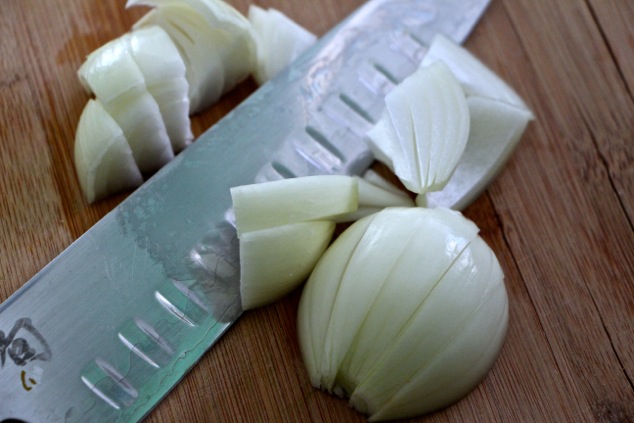 cutting onion on cutting board
