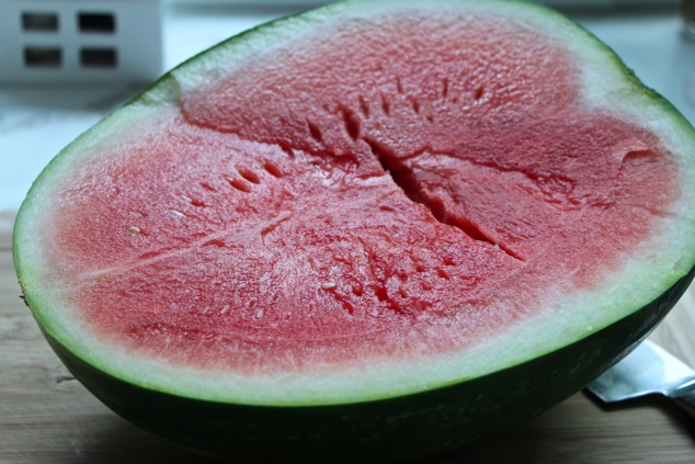 Watermelon halved in cutting board
