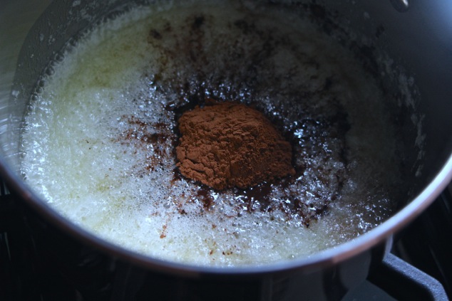 adding cocoa powder to saucepan