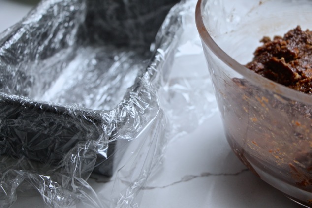 cake pan lined up with plastic wrap