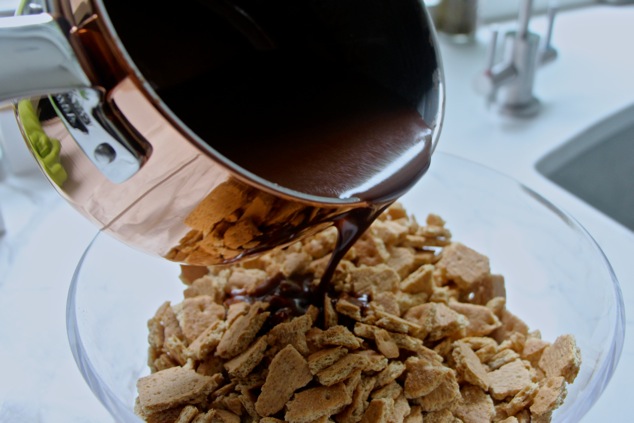 pouring fudge on graham cracker pieces