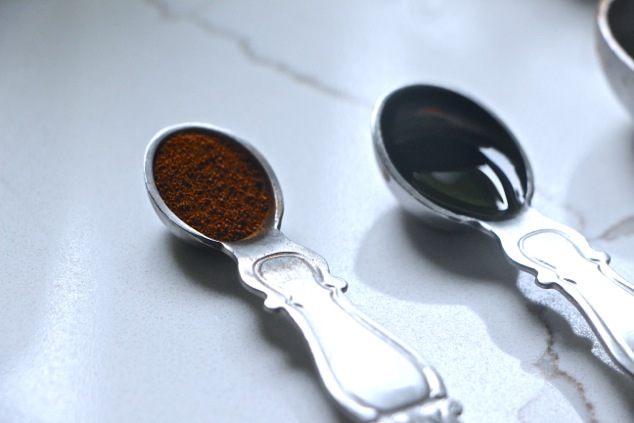 vanilla extract and coffee powder in measuring spoons
