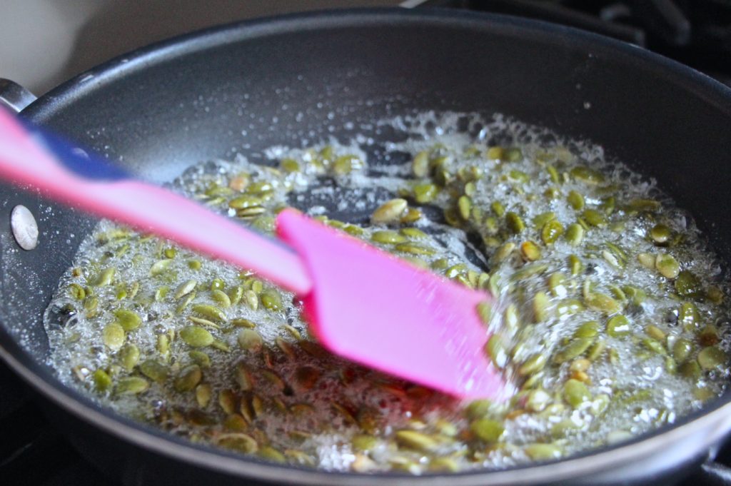 mixing pumpkin seeds in sugar syrup